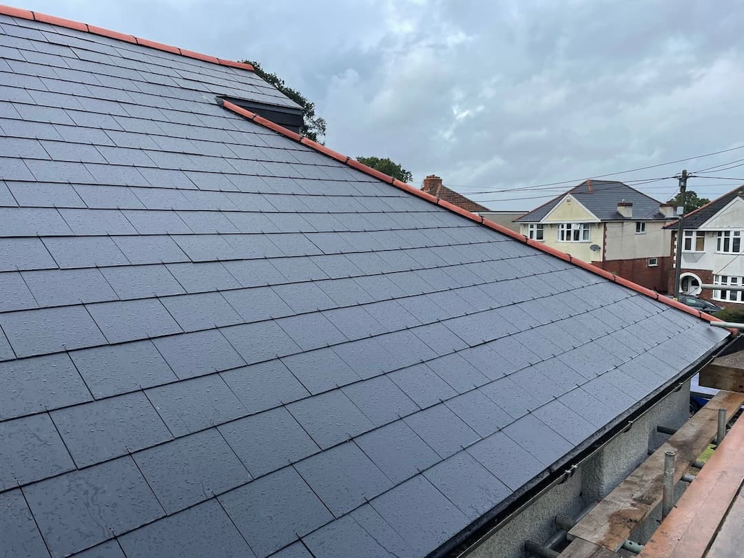 Finished grey slate roof with chimney