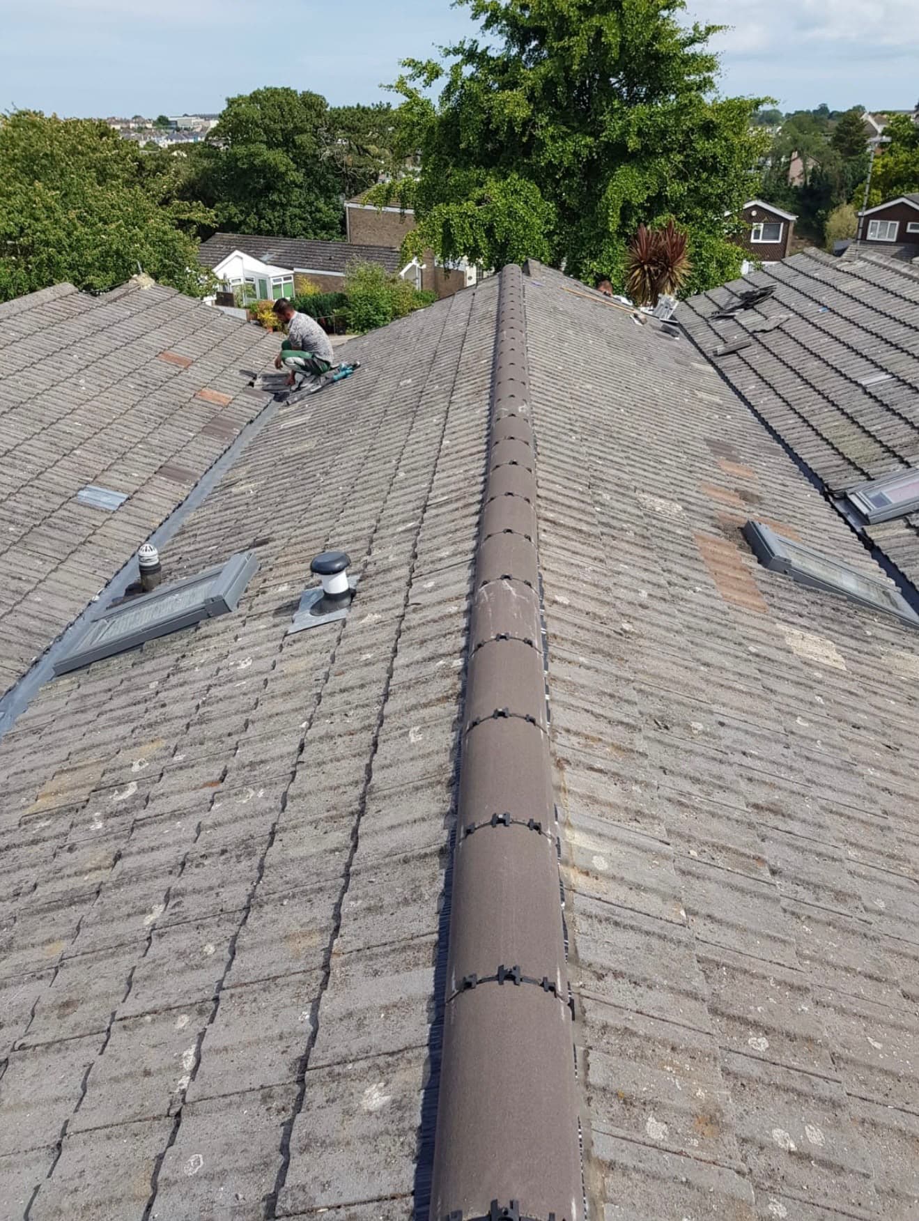Work in progress along a pitched roof ridge